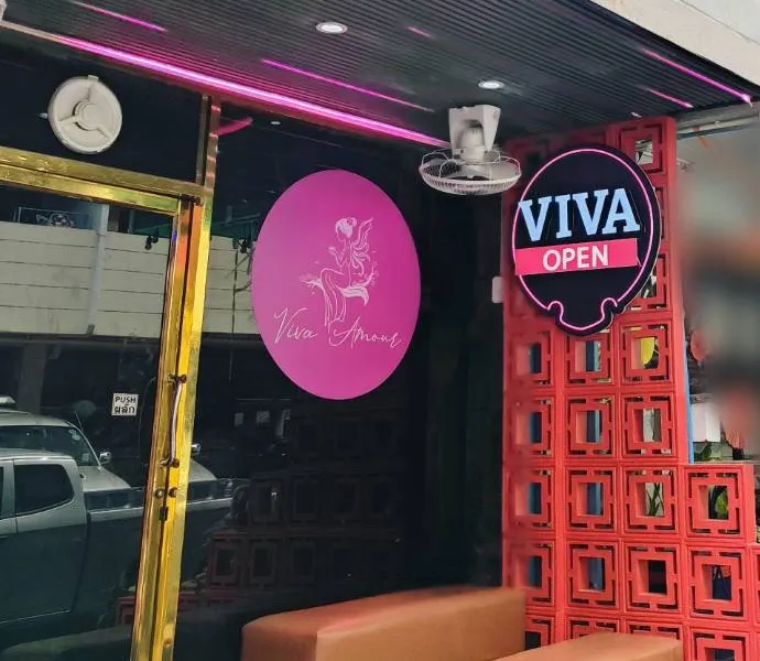 Former entrance with a round pink Viva Amour logo, red screen blocks and benches