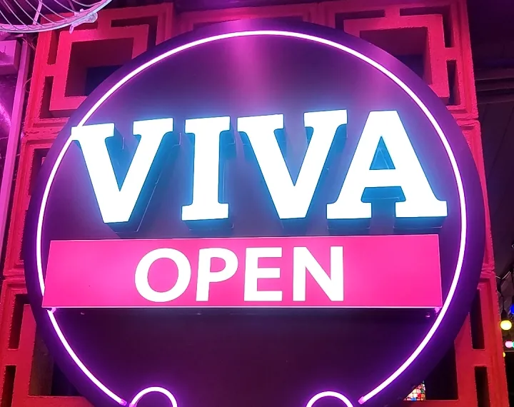 Illuminated round VIVA sign outside the venue